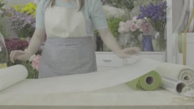 Çiçekçi dolly atış bir buket sarma kağıt hazırlama, derecelendirilmemiş sesi