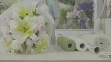 Çiçekçi kadın kağıt, ungraded sesi ile bir çiçek buketi sarma