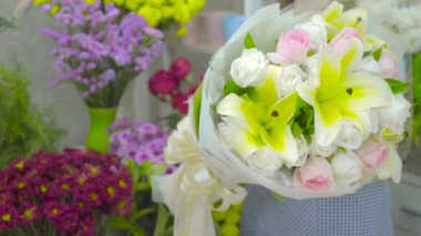 Çiçekçi kadın bir müşteriye güzel bir çiçek buketi veren