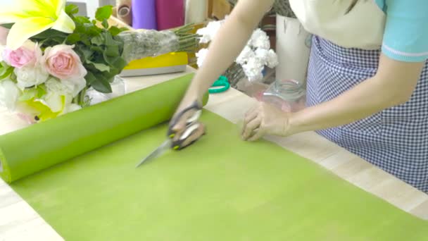 Florist kvinna förbereder papper för att Linda en blomma bukett — Stockvideo