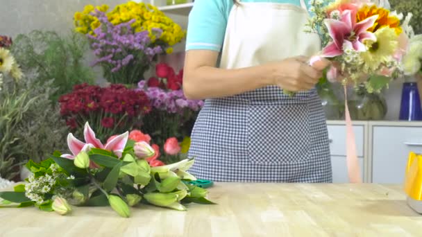 Dolly strzał Kwiaciarnia kobieta wiążąca wstążkę na bukiet kwiatów — Wideo stockowe