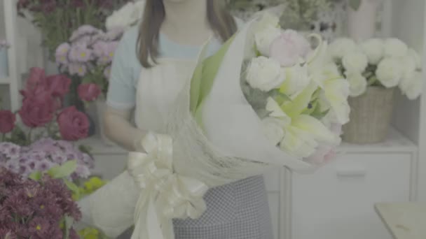 Florist woman giving a beautiful flower bouquet to the camera, ungraded tone — Stock Video