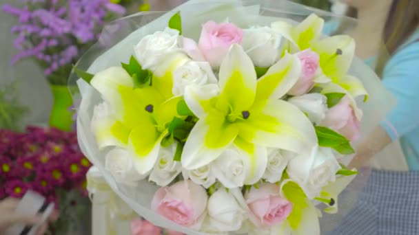 Customer paying money for a flower bouquet with credit card to florist woman — Stock Video