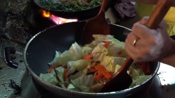 Yellow noodles are being fried in hot frying pan in slow-motion — Αρχείο Βίντεο