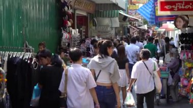 İnsanlar alışveriş için modern giyimleri Tha Wanglang iskelede tadını çıkarıyor