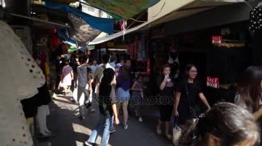 İnsanlar alışveriş için modern giyimleri Tha Wanglang iskelede tadını çıkarıyor