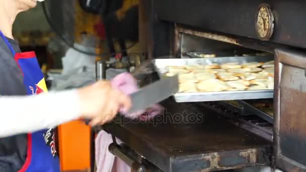 Атмосфера в пекарне. люди приносят много хлеба из горячей печи — стоковое видео
