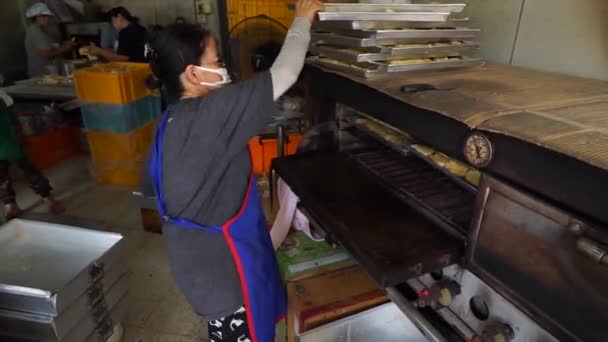 A hangulat a pékség bolt. emberek hozzák ki egy forró tűzhely sok kenyér — Stock videók