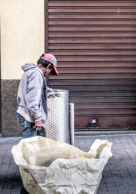 Efendim, çöpten yemek topluyor ve kapı arkasında bekliyor.