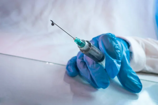 青い手袋10を使用してCovid 19の治療のための注射器のワクチンのドロップ — ストック写真