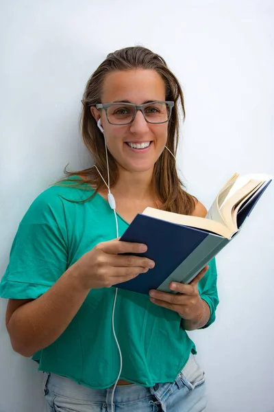 Woman reading a book and listening music in quarantine