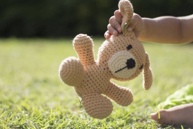 Çocuk oyuncak hayvanını parkta tutuyor.