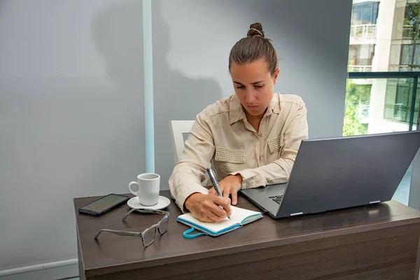 Female administrative working in the office and taking notes