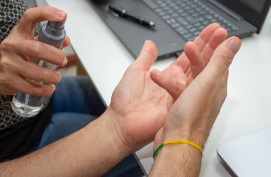 İş yerindeki kadın, ortağının eline alkol veriyor.