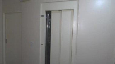 Maskeli kadın asansörden çıkıyor.