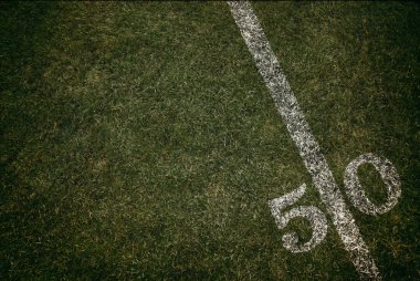Futbol alan çim çim zemin 50 yard çizgisinde. Cuma gece ışık.