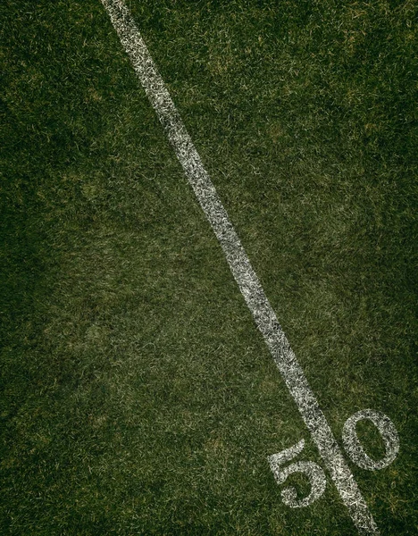 Campo de fútbol césped tierra cincuenta yardas línea. Viernes por la noche luces . — Foto de Stock