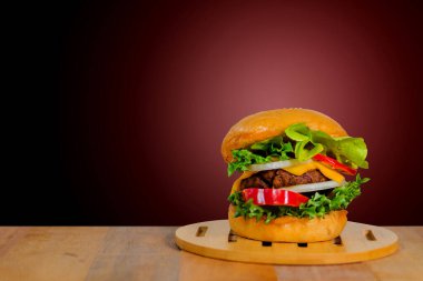 Tahta bir tepside hamburger ve ahşap bir masa.