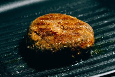 Hamburg eti tavada kızartılıyor. Hamburgerin ana malzemelerinden biri..