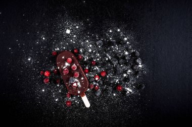 Dondurma, kızılcık, böğürtlen, siyah arka planda.