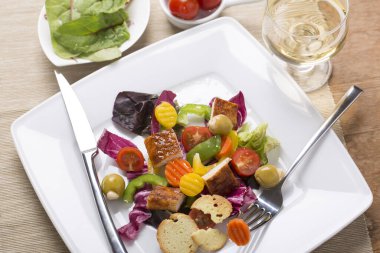 Tabakta çeşitli sebzelerle ızgara tavuk göğsü salatası