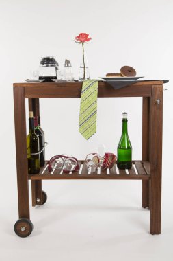 Alkol şişeleri ve beyaz arka planda gül olan ahşap masa.