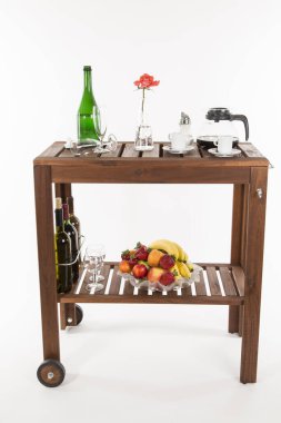 Alkol şişeleri ve beyaz arka planda gül olan ahşap masa.