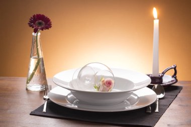 Kahverengi arkaplanda mum ışığı olan romantik set masası