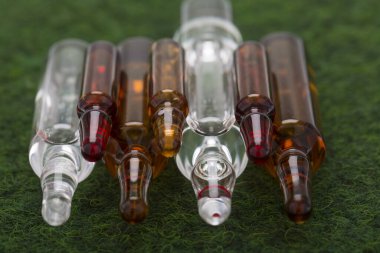 Yeşil yüzeyde sıvı içeren ampule