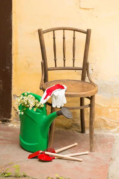 watering can and wooden chair