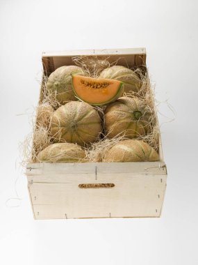 Eski ahşap arka planda saman üzerinde kavunlar