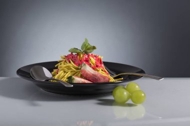 Çatal bıçakla süslenmiş çilekli spagetti sundae.