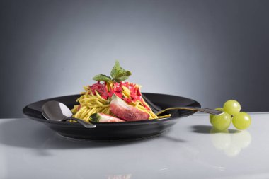 Çatal bıçakla süslenmiş çilekli spagetti sundae.