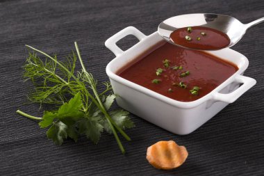 Tabakta domates çorbası ve menü kartı için taze sebzeler.