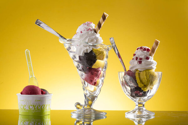 colorful ice cream cup and plastic cup decorated on yellow background 