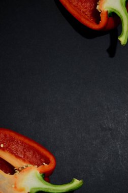 Siyah arkaplan dikey yönelimine sahip Bulgar biberinin yarısının çerçevesi