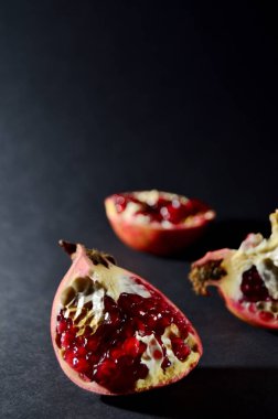 Koyu arkaplan üzerinde kırmızı nar parçaları kopya alanı dikey yönelimli