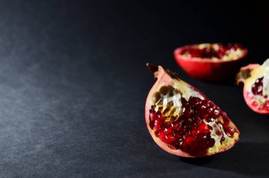 kırmızı nar parçalarının koyu arkaplanı yatay olarak kopyala