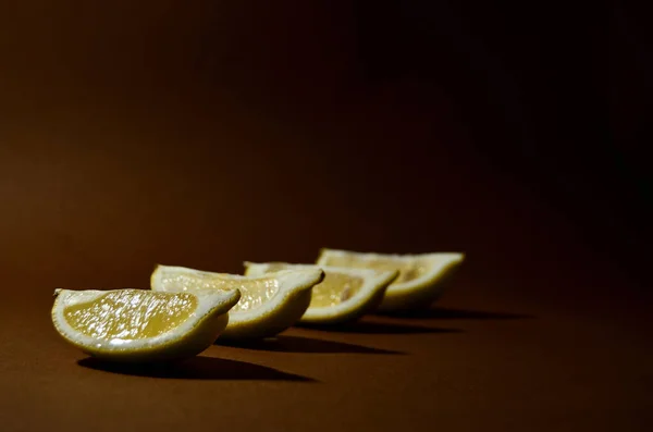 Vier Scheiben Gelbe Zitrone Auf Braunem Hintergrund Horizontal Ausgerichtet — Stockfoto