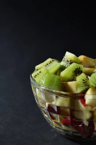 Plátky Kiwi Banán Jablko Skleněné Váze Zblízka Černém Pozadí Vertikální — Stock fotografie