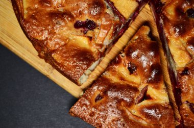 Tahta üzerinde kesilmiş bir parça turta yukarıdan siyah arkaplan görüntüsüne yakın plan