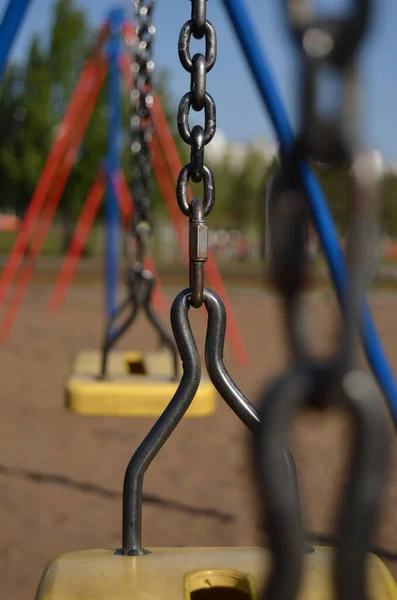 swing on the chain close-up at the playground in the park vertical orientation