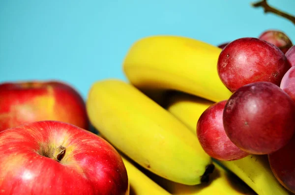 가까운 곳에 있는 과일 사과 바나나 포도는 파란 배경 위에 놓여져 있다 — 스톡 사진