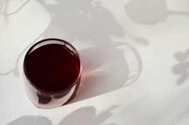 Beyaz arka planda üzümlü bir bardak, yukarıdan gölgelik manzaralı, kuşüzümü suyu.