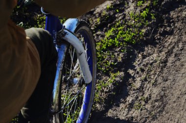 Kırsal bir yolda giden bir bisikletin tekerlekleri.