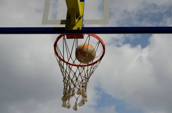 Soccer ball in a basketball ring against cloudy cloudy sky — Stock Photo, Image