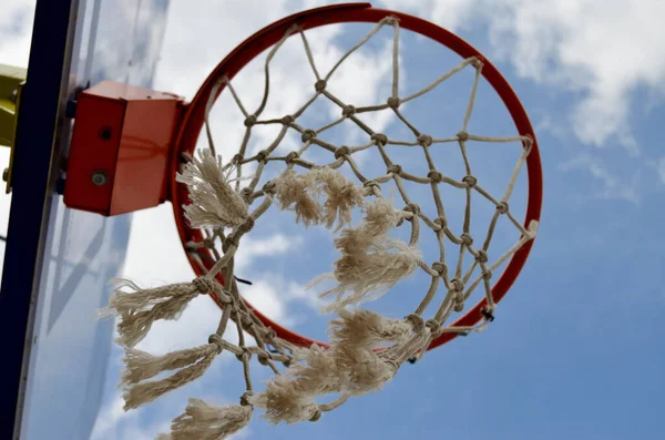 Basketball ring close-up from below wind swaying mesh against blue sky — Stock Photo, Image