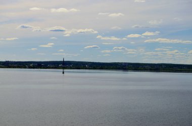 Şehirden nehrin manzarası mavi gökyüzünün altında bulutlu.