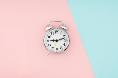Mavi pembe kağıt arkaplanda alarm saati