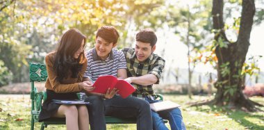 Parkta kitap okuyan gençler. Okuyarak öğrenim.